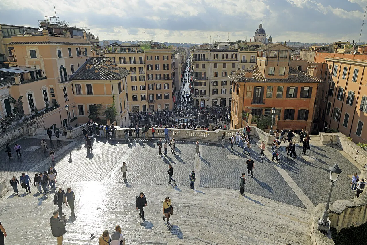 View from the top of the Spanish Steps down Via dei Condotti, with the dome of St Peter's on Rome's skyline