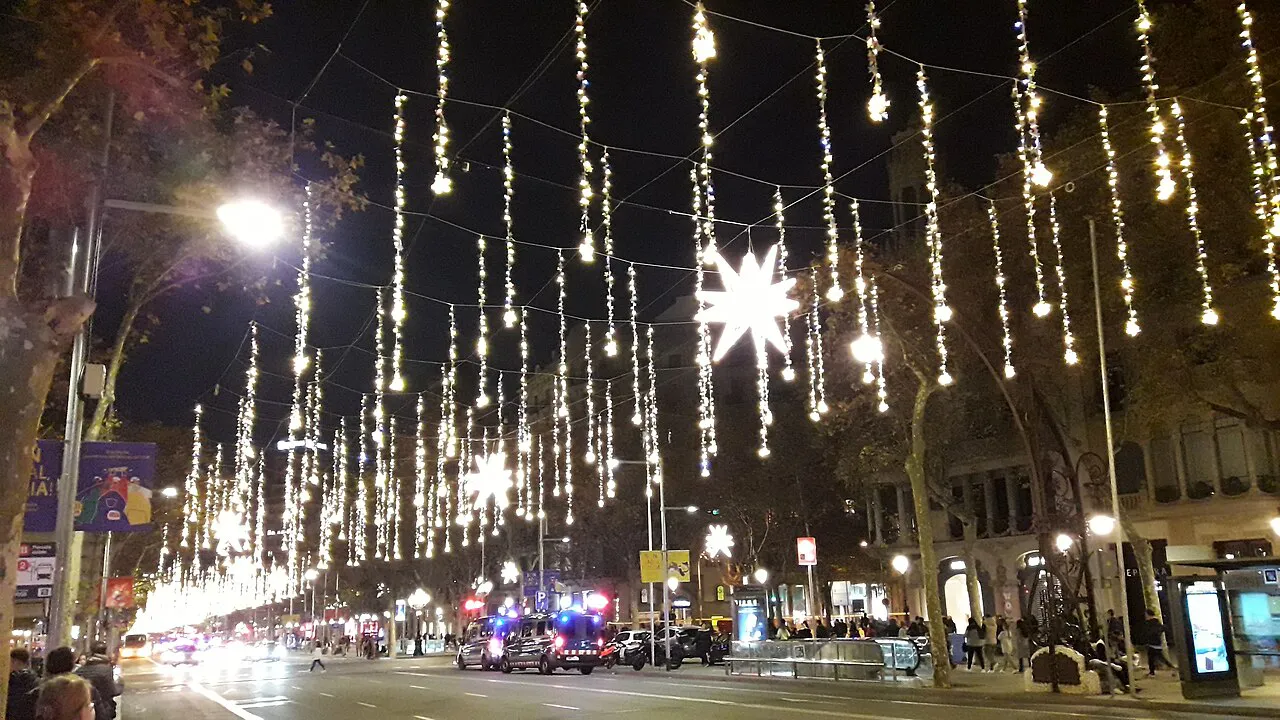 Strings of Christmas lights hanging over Passeig de Gràcia at night in Barcelona