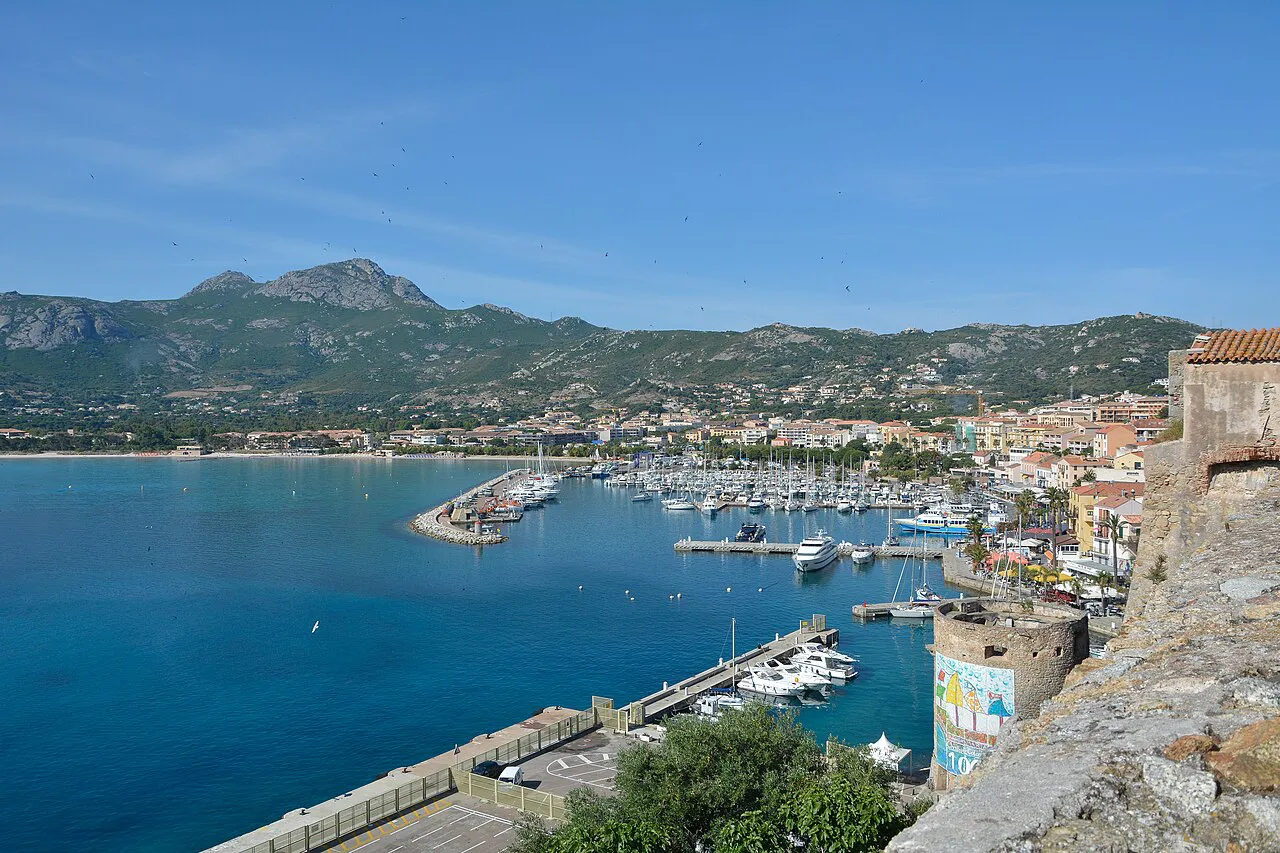 Calvi marina and blue bay seen from the citadel walls, with the Capu di a Veta mountain behind