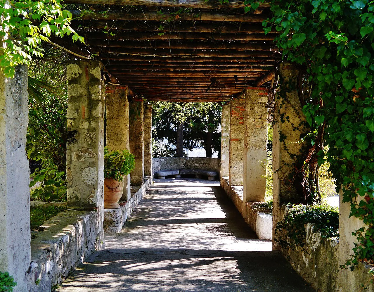 Shaded vine-covered stone pergola in the cloister garden of Cimiez Monastery, Nice