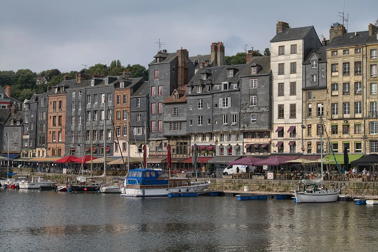 Tall slate-faced and timber houses on Quai Sainte-Catherine reflected in Honfleur’s old harbour