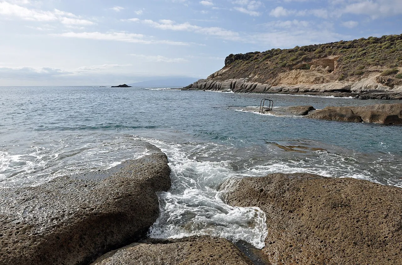 Atlantic waves breaking over smooth volcanic rocks on the shore at La Caleta, Tenerife