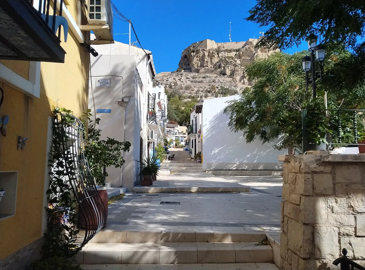 Whitewashed stepped lane of Calle San Antonio in Alicante's Santa Cruz quarter with the castle hill above