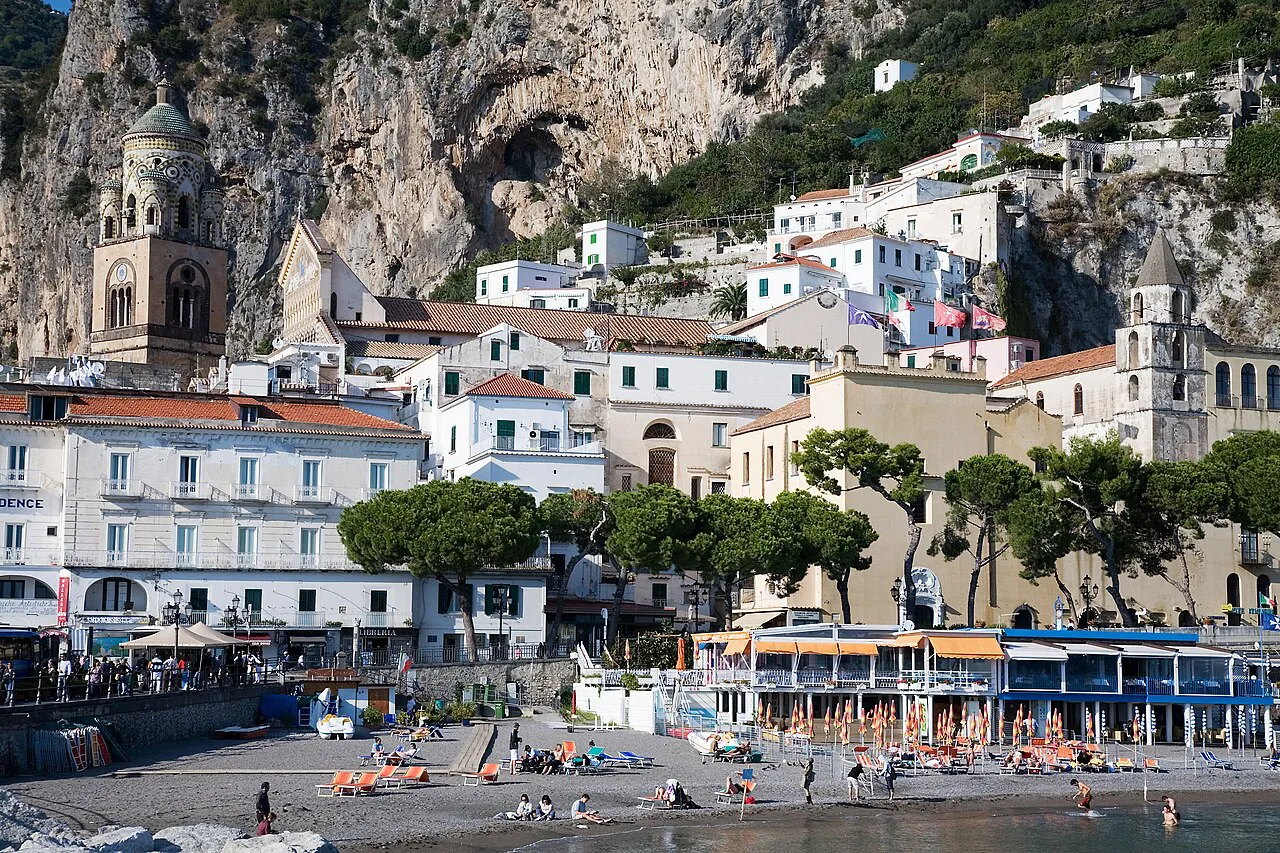 Marina Grande beach in Amalfi below white town buildings, the cathedral tower and limestone cliffs
