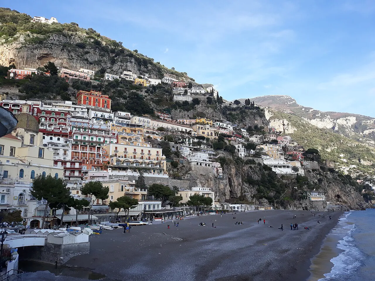 Positano's pastel houses stacked up the cliffs above its long dark-sand beach