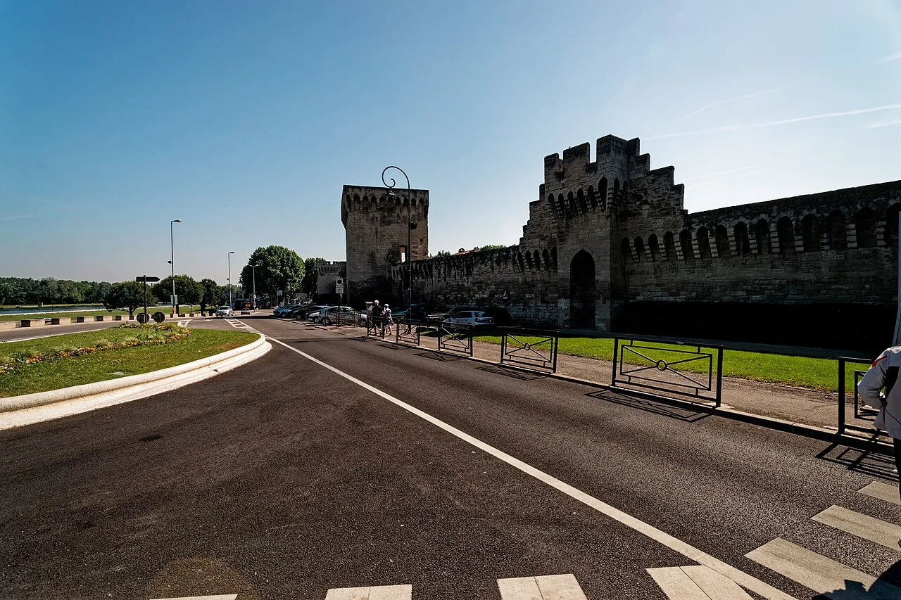 Crenellated medieval ramparts and gate towers of Avignon along Boulevard de l’Oulle under a blue sky