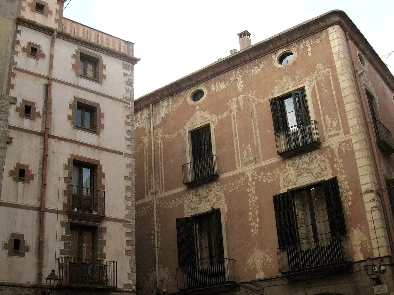 Old painted facades of Palau Moxó and neighbouring houses on Plaça de Sant Just in Barcelona's Gothic Quarter