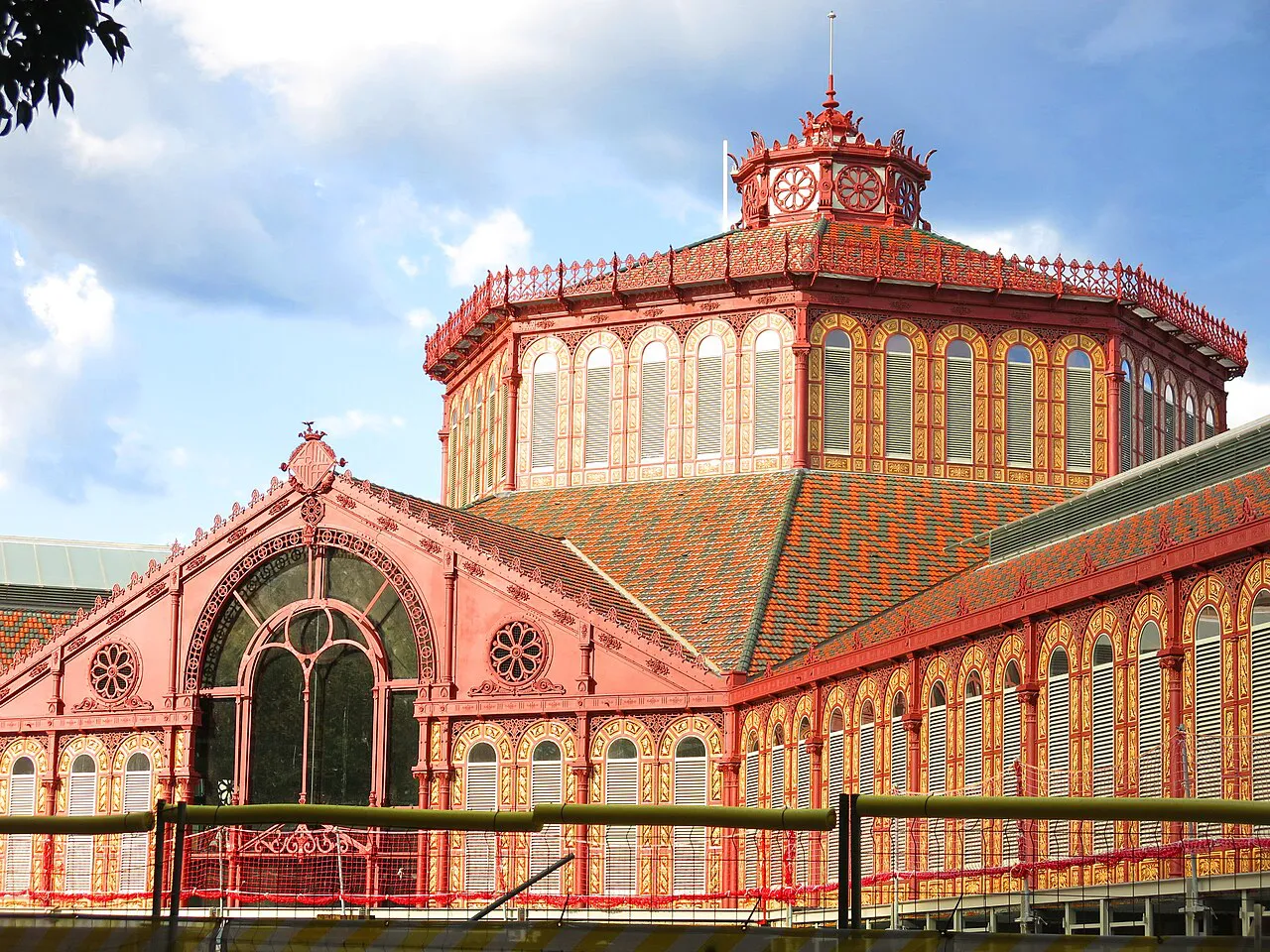 Octagonal red-and-cream cupola and iron facade of the Mercat de Sant Antoni in Barcelona