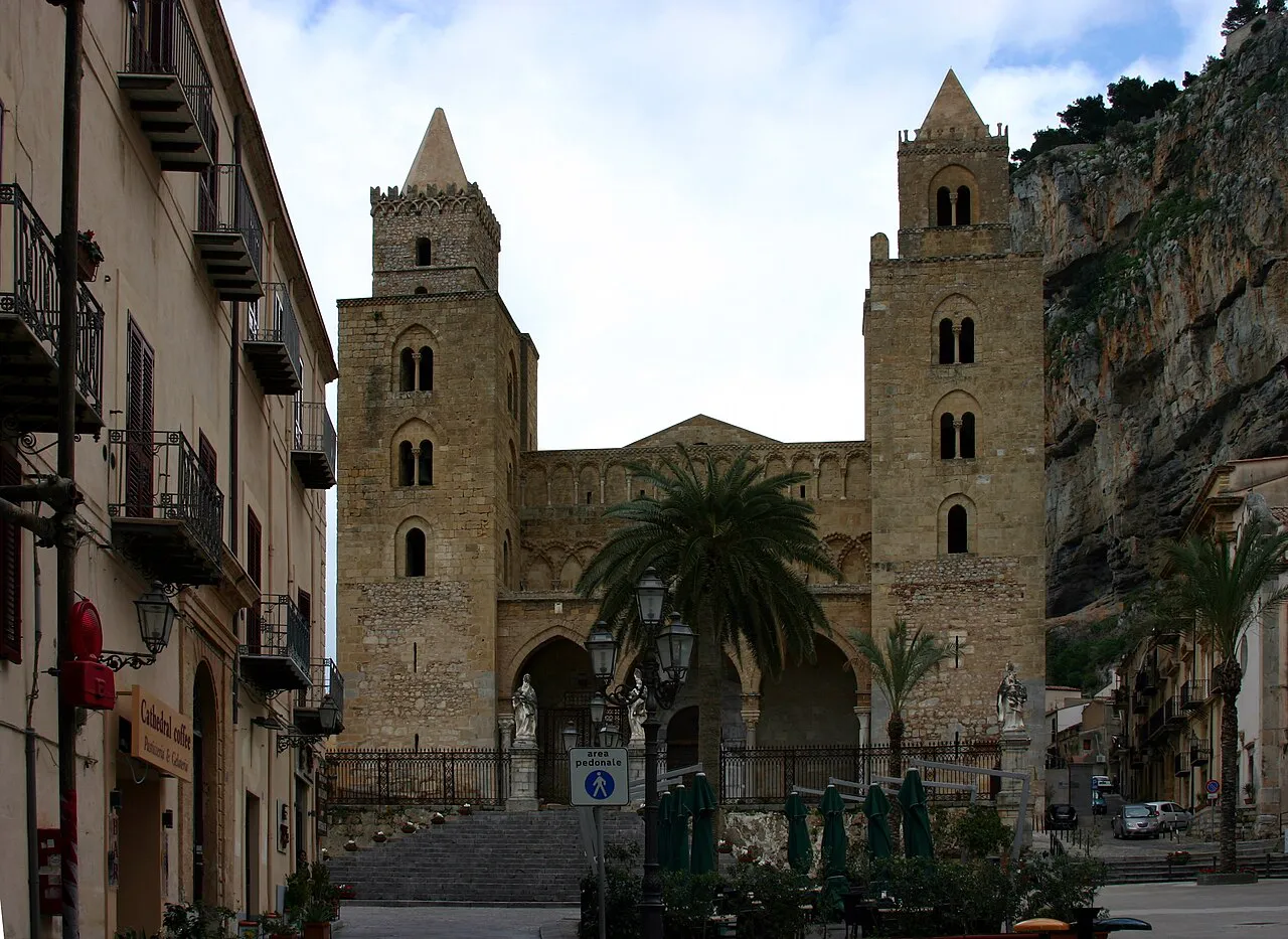 Twin Norman towers of Cefalù Cathedral beneath the cliffs of the Rocca, seen from the piazza