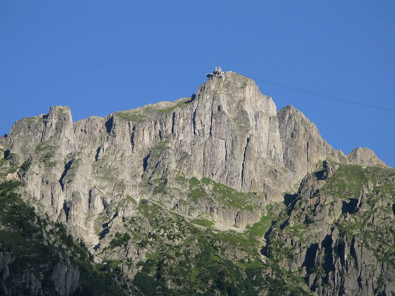 The rocky summit of Le Brévent rising above the Chamonix valley under a clear blue sky