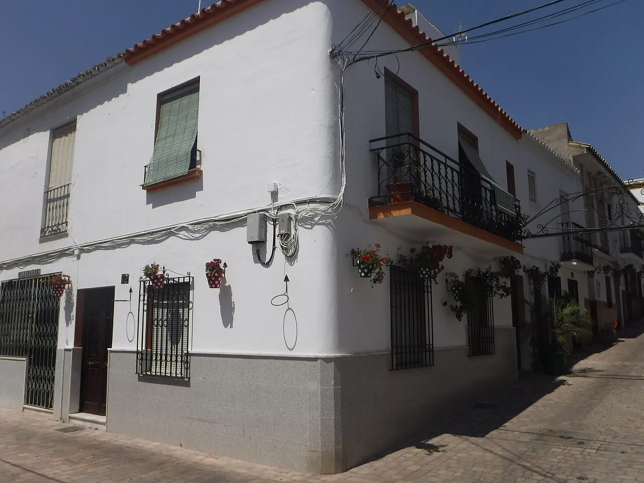 Whitewashed houses with iron balconies and flowerpots on a street corner in Estepona’s old town