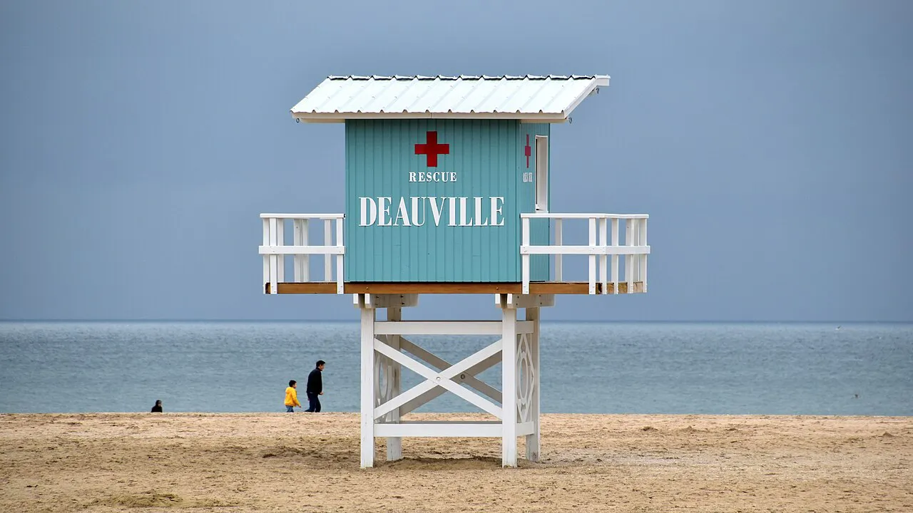 Pale blue lifeguard station marked Deauville standing on the sandy beach by the sea