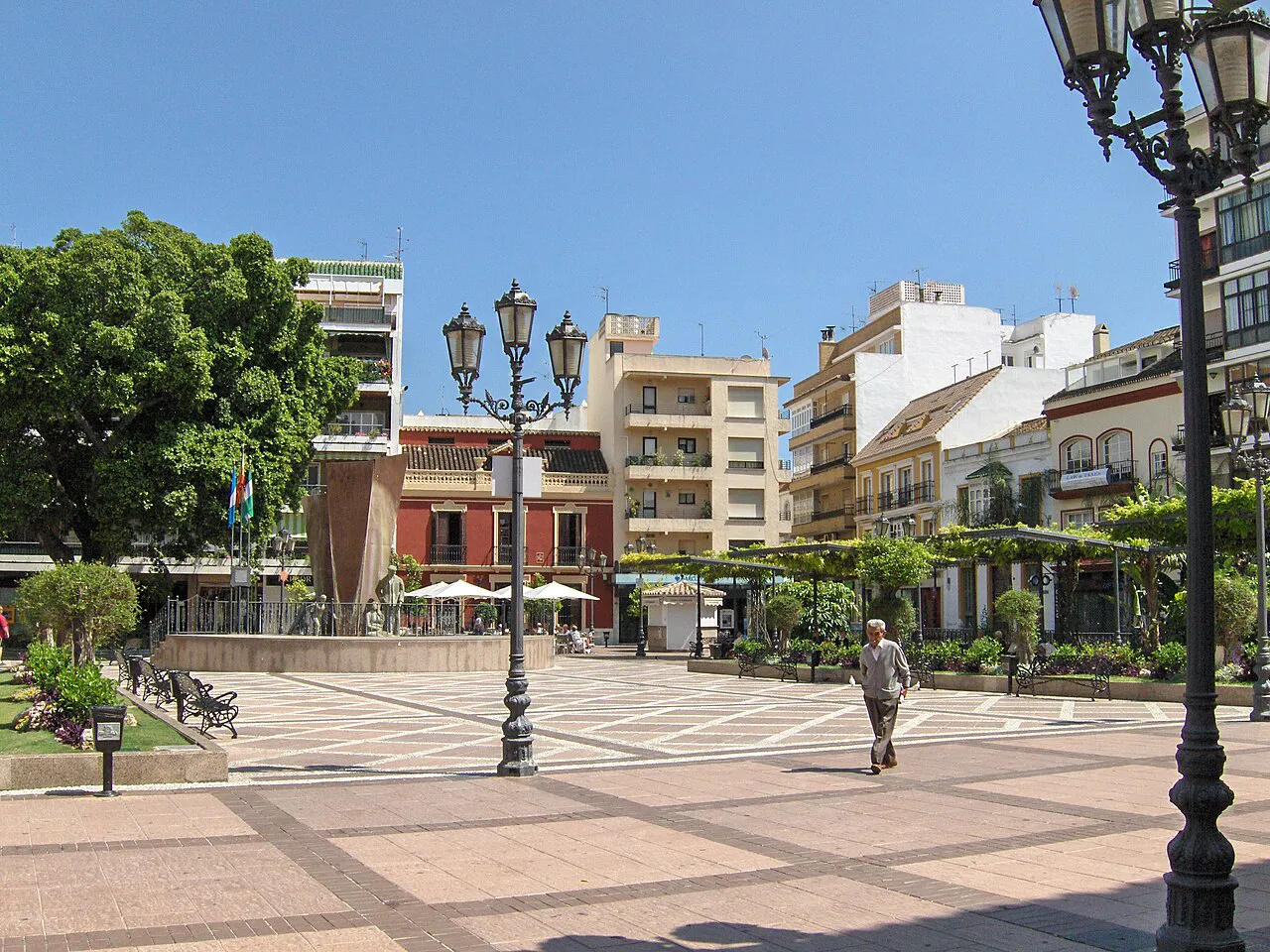 Paved Plaza de la Constitución with ornate lamp posts and trees in the centre of Fuengirola