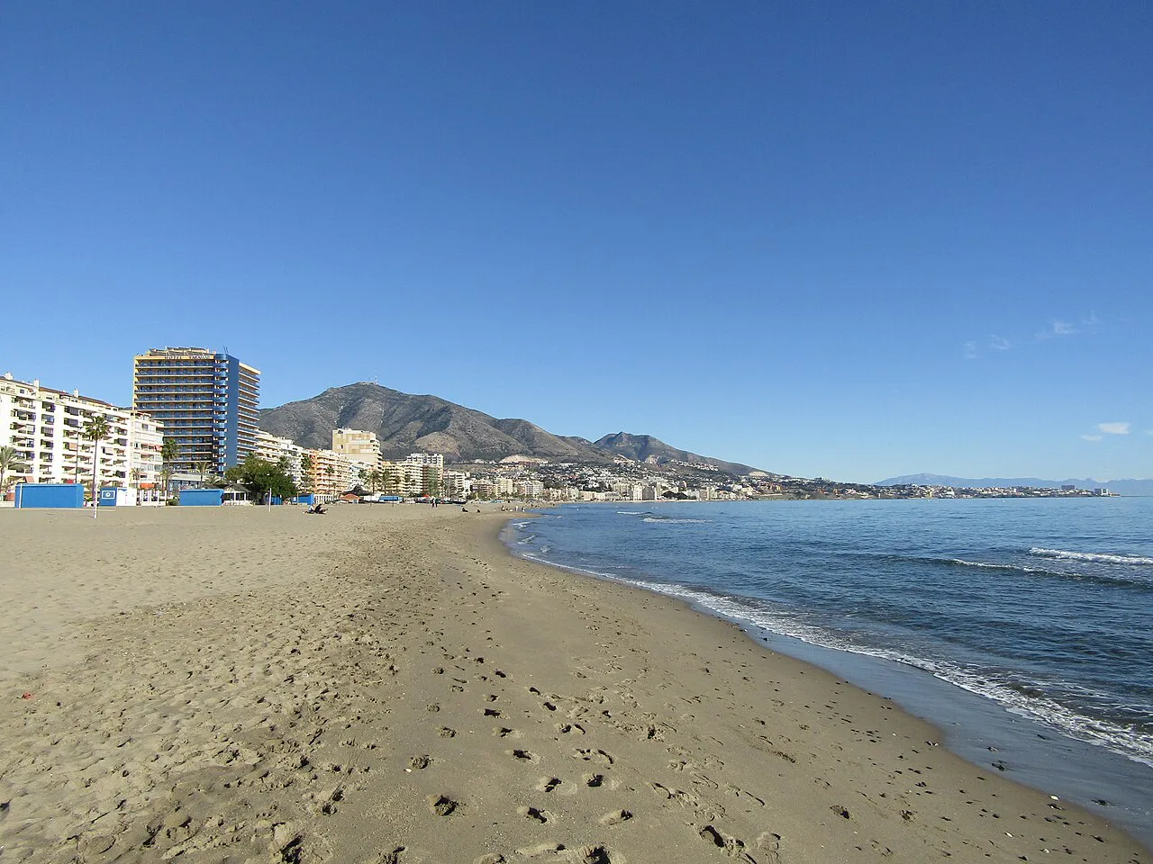 Wide sandy Playa de los Boliches curving north along the sea towards the mountains, Fuengirola
