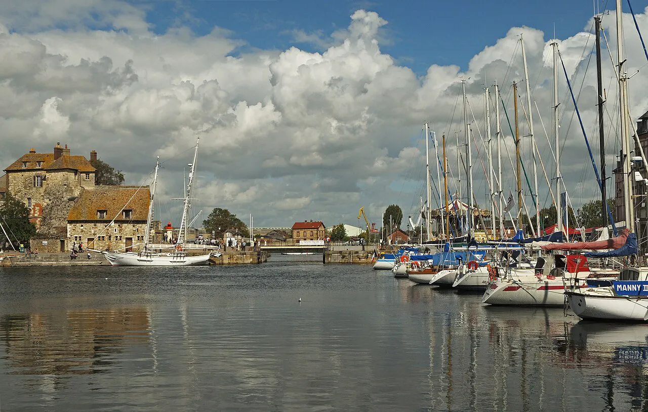 Sailing boats moored in Honfleur's old harbour with the stone Lieutenance at the harbour mouth