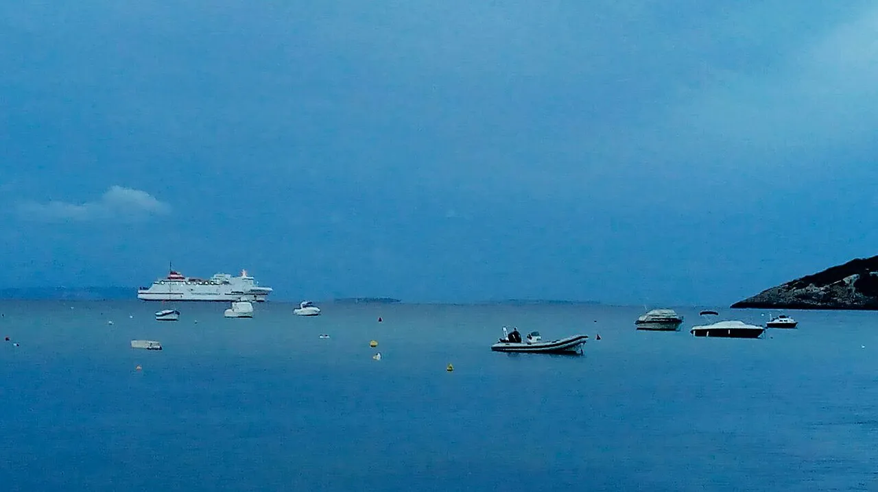 Boats anchored on calm blue water in Talamanca Bay beside Ibiza Town