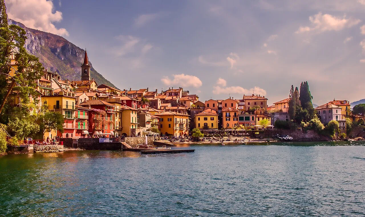 Colourful houses of Varenna lining the shore of Lake Como beneath steep wooded mountains