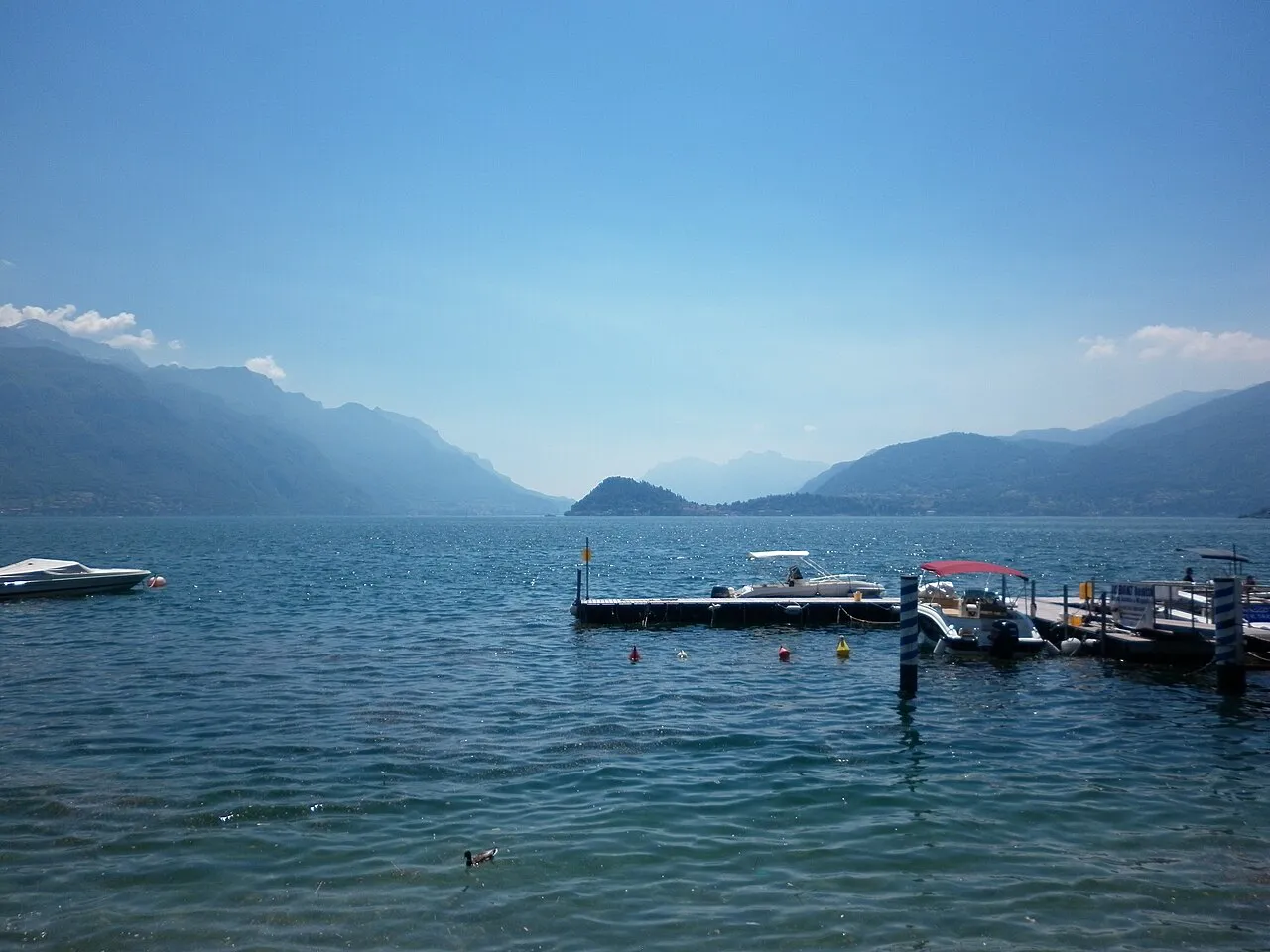 Boat jetty on Lake Como at Bellagio, with blue mountain ridges fading into the distance