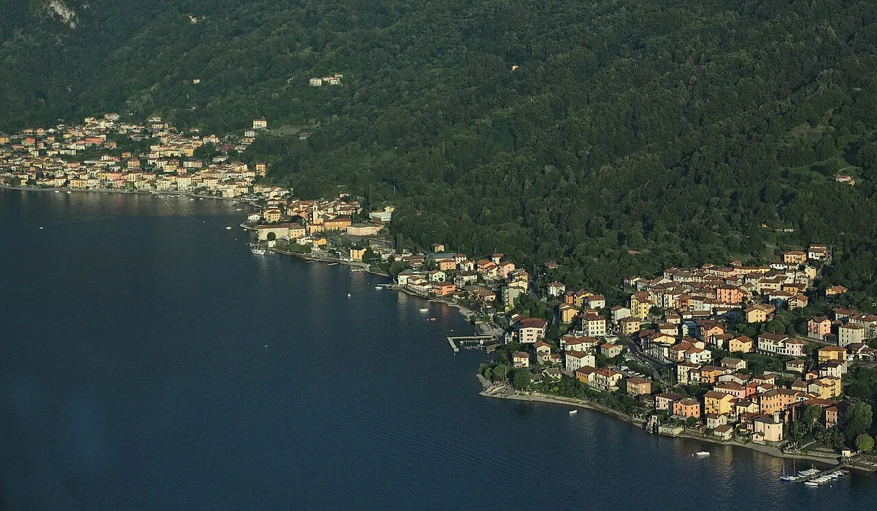 Aerial view of Lezzeno's houses strung along the wooded shore of Lake Como