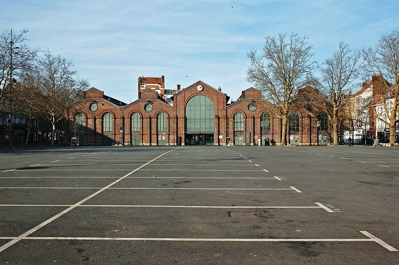 Brick market hall of Les Halles de Wazemmes behind an open square in Lille