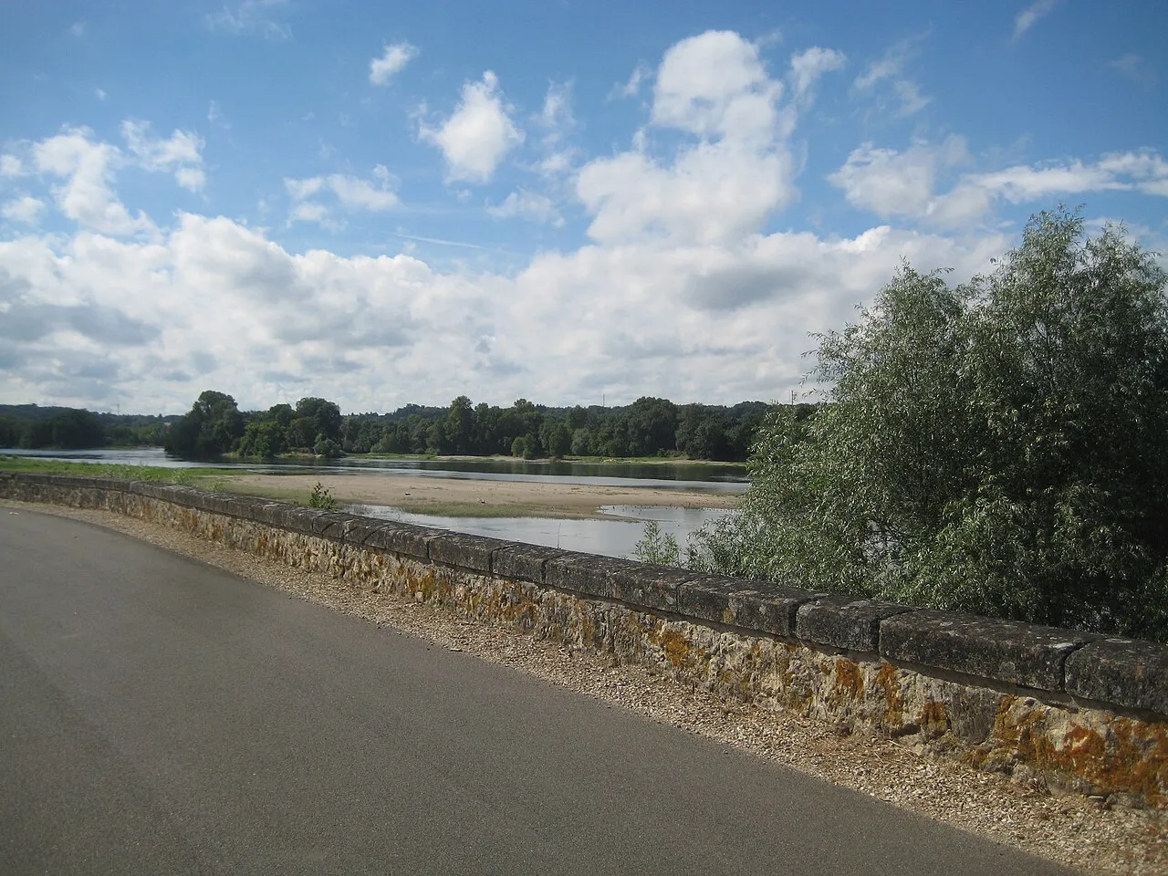 A paved Loire à Vélo cycle path running along a stone embankment beside the Loire at La Chapelle-aux-Naux