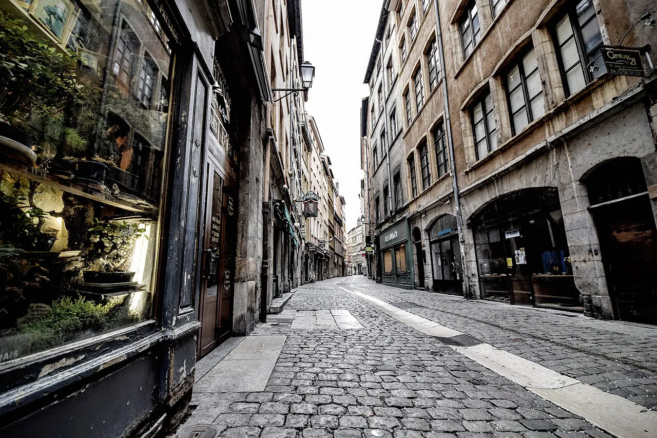 Quiet cobbled street lined with old stone buildings and shopfronts in Vieux Lyon