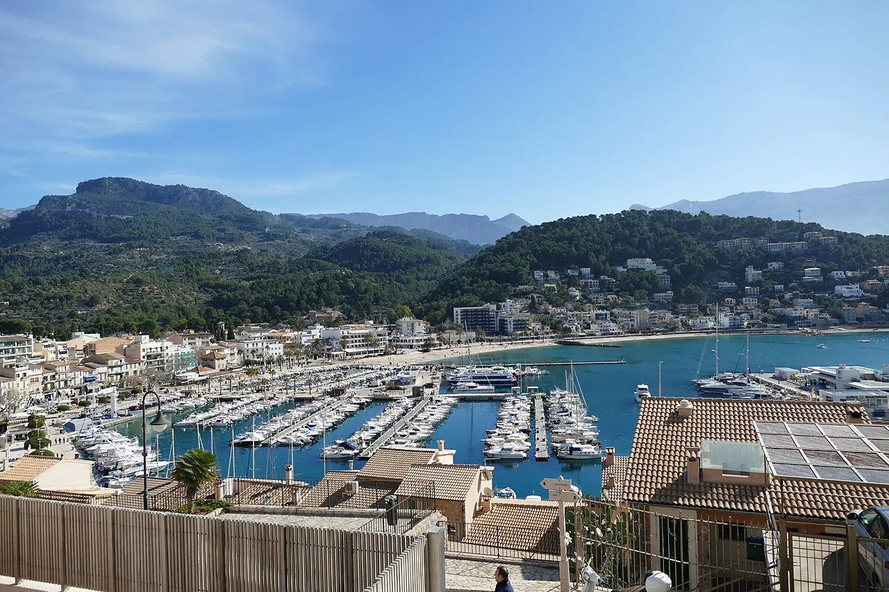 Port de Sóller marina and bay seen from above the rooftops, with Tramuntana hills behind