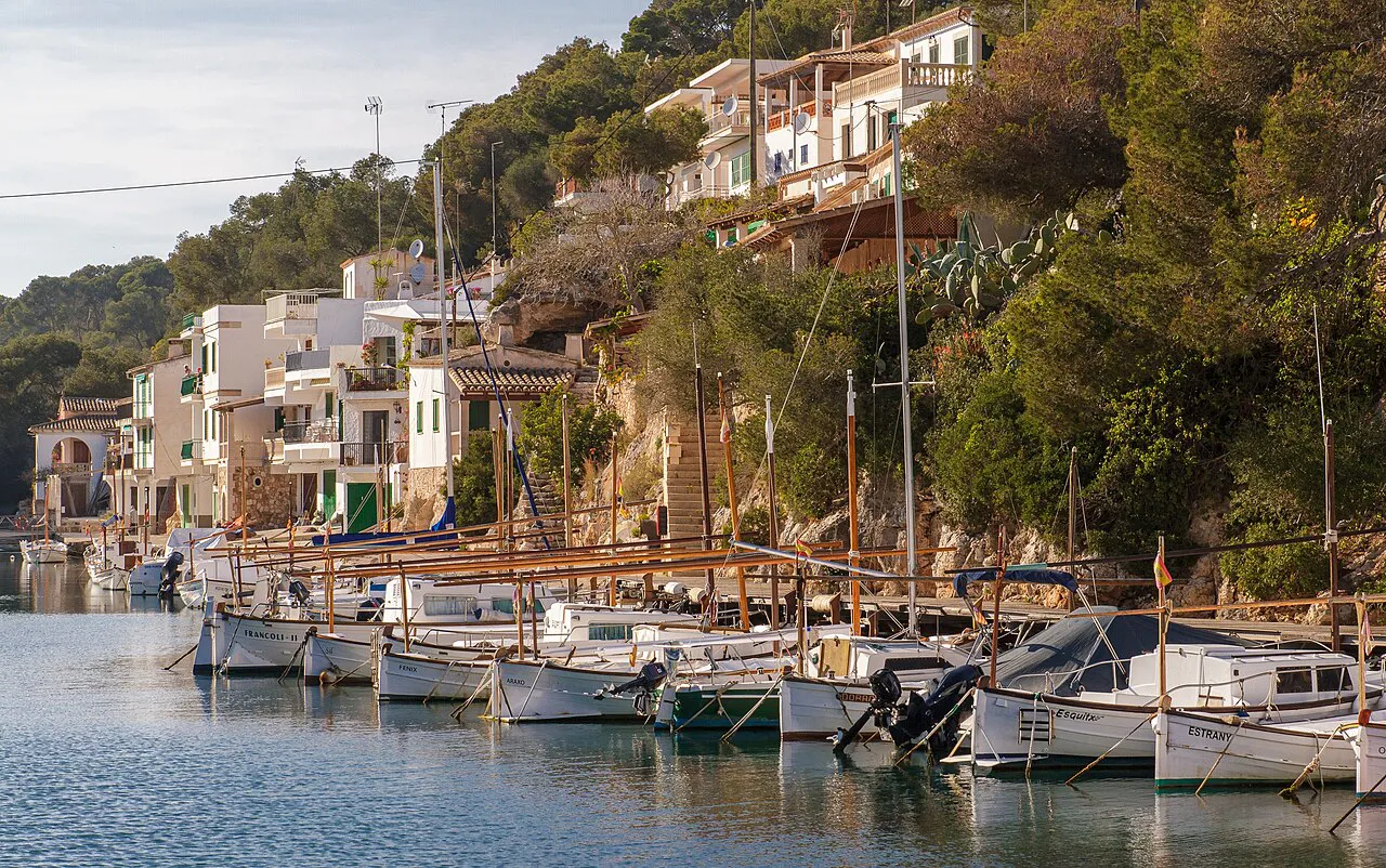 Fishing boats moored along the narrow inlet at Cala Figuera, lined with white harbour houses