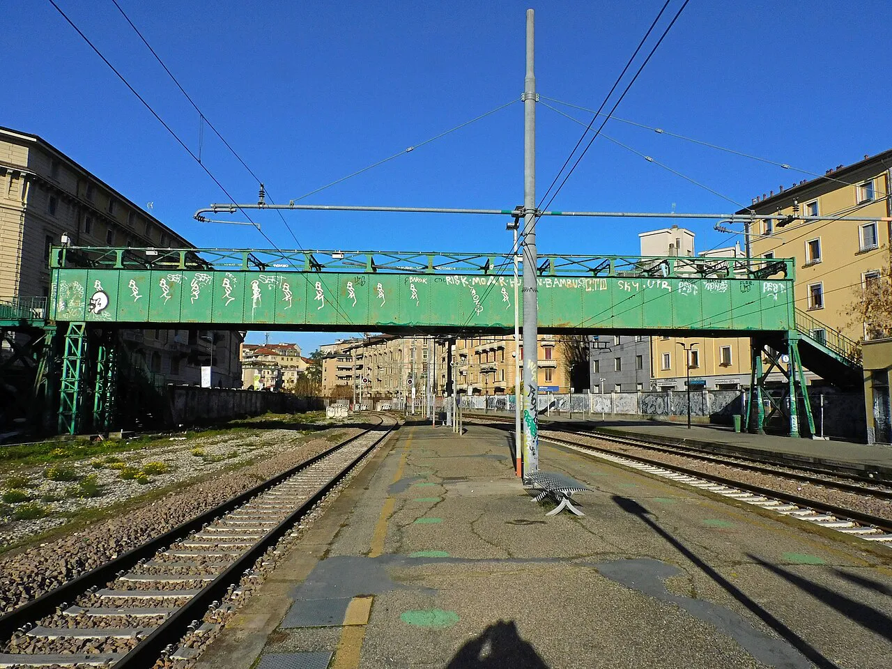 Green iron Ponte degli Artisti footbridge over the railway yard at Porta Genova, by Milan’s Tortona district