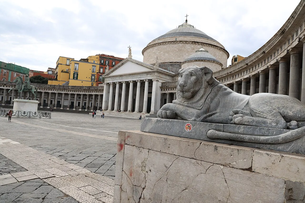 Piazza del Plebiscito with a stone lion and the domed Basilica of San Francesco di Paola, Naples