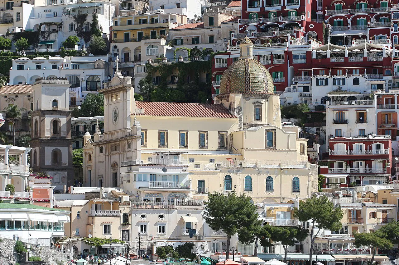 Tiled dome of Santa Maria Assunta among the pale houses of Positano's lower village