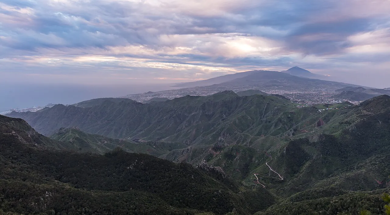 Green ridges of the Anaga Rural Park under evening clouds, with Mount Teide on the horizon