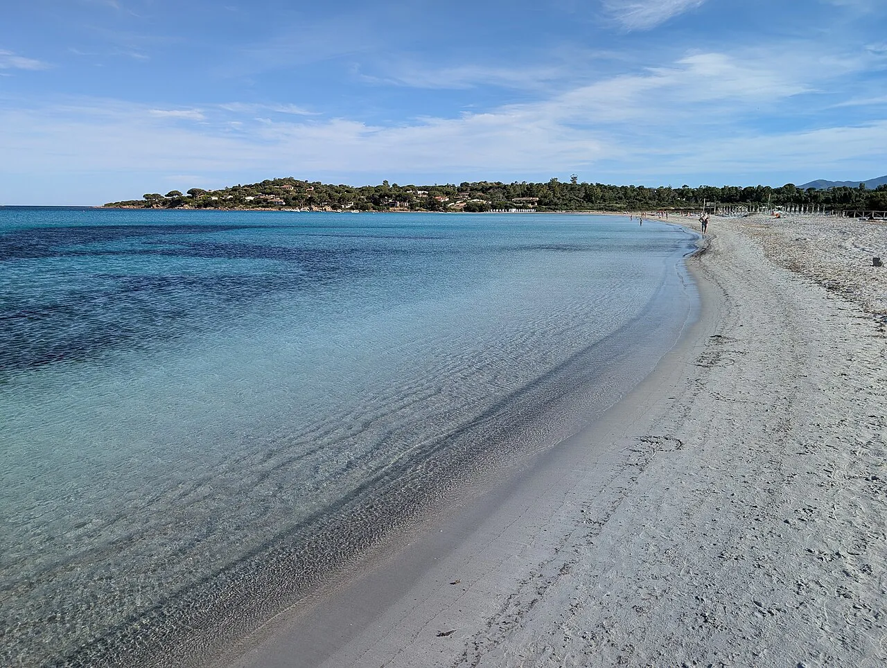The long white sand beach of Lu Impostu at San Teodoro curving along clear turquoise water