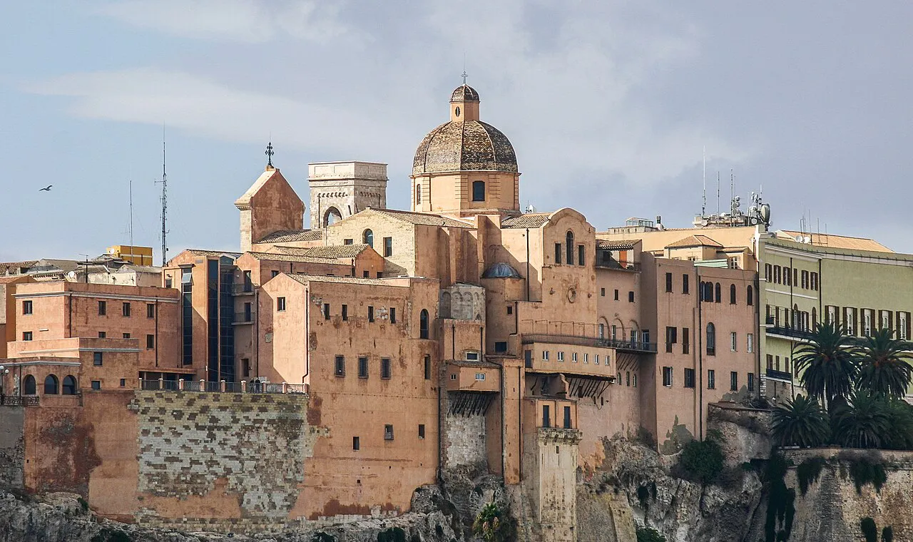 The domed Cagliari Cathedral rising above the old stone walls and buildings of the Castello quarter, Sardinia