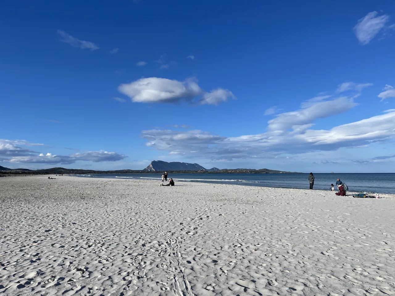 Wide white sand of La Cinta beach at San Teodoro with Tavolara island on the horizon