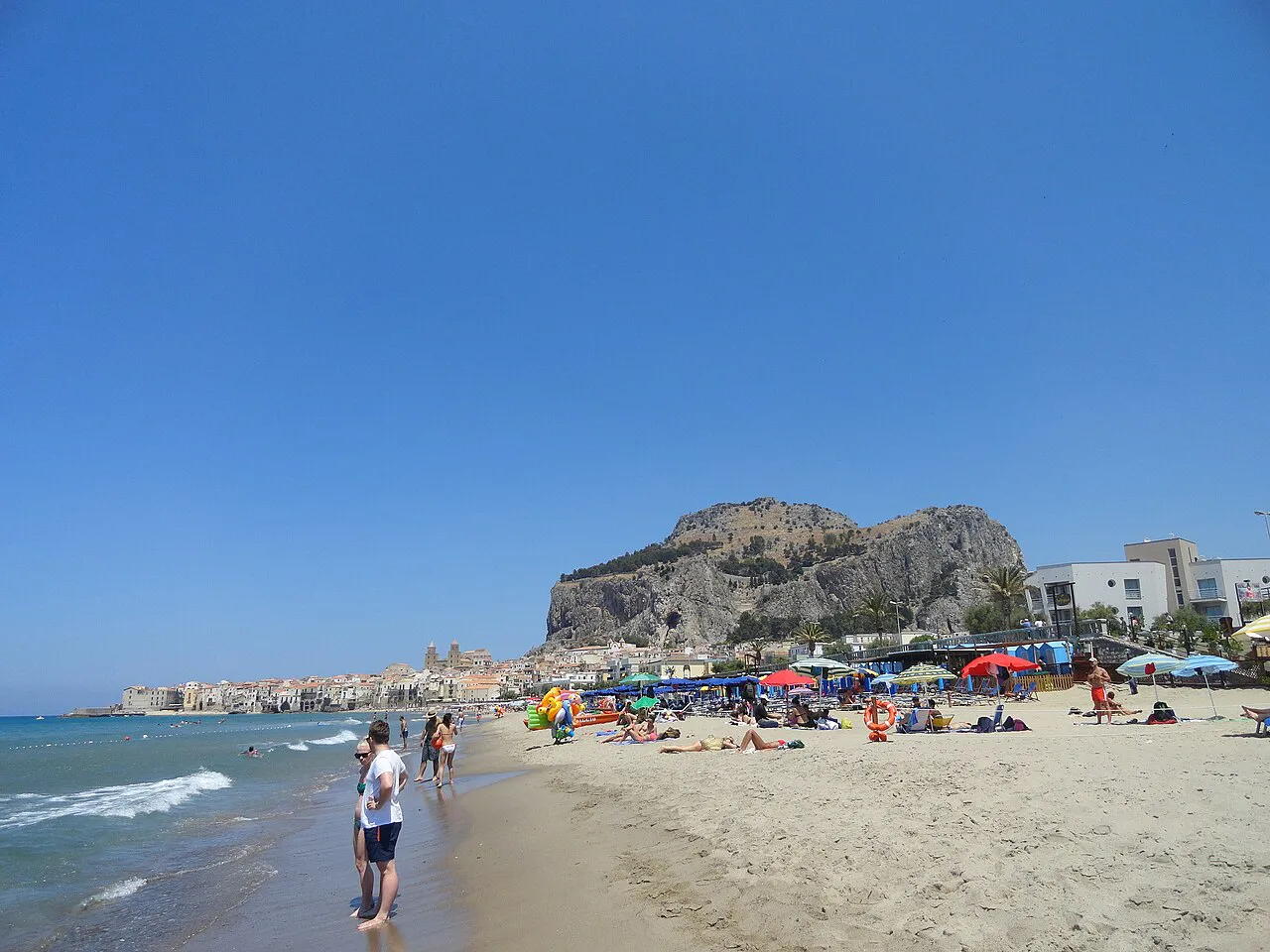 Cefalù’s long sandy beach with the great limestone Rocca rising above the town
