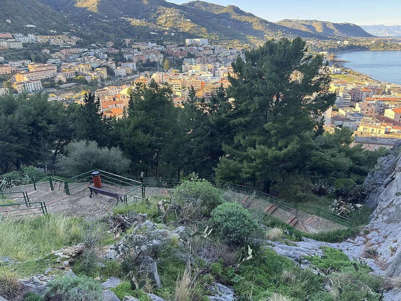 Cefalù’s rooftops and the coast seen from the wooded path up La Rocca