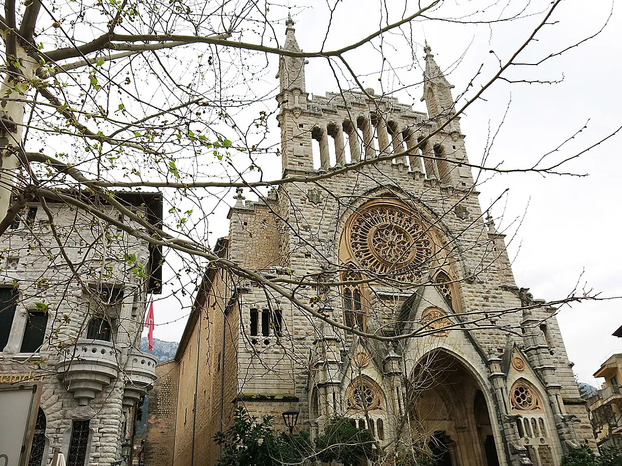 Modernista facade and rose window of the church of Sant Bartomeu in Sóller town, beside the former Banc de Sóller