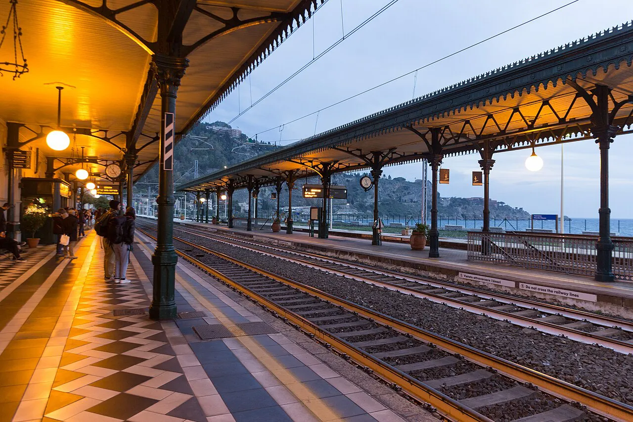 Iron canopies and patterned platform of Taormina-Giardini railway station by the sea