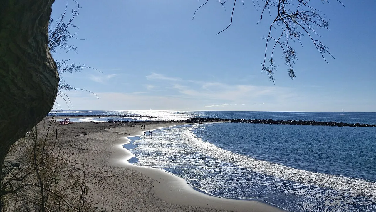 Waves curling onto the sandy curve of Playa de Troya in Costa Adeje, Tenerife